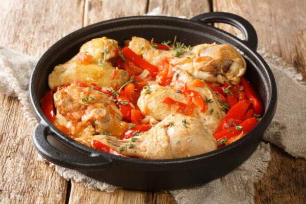 Basque Chicken or Poulet Basquaise with vegetables close up in the pan. Horizontal